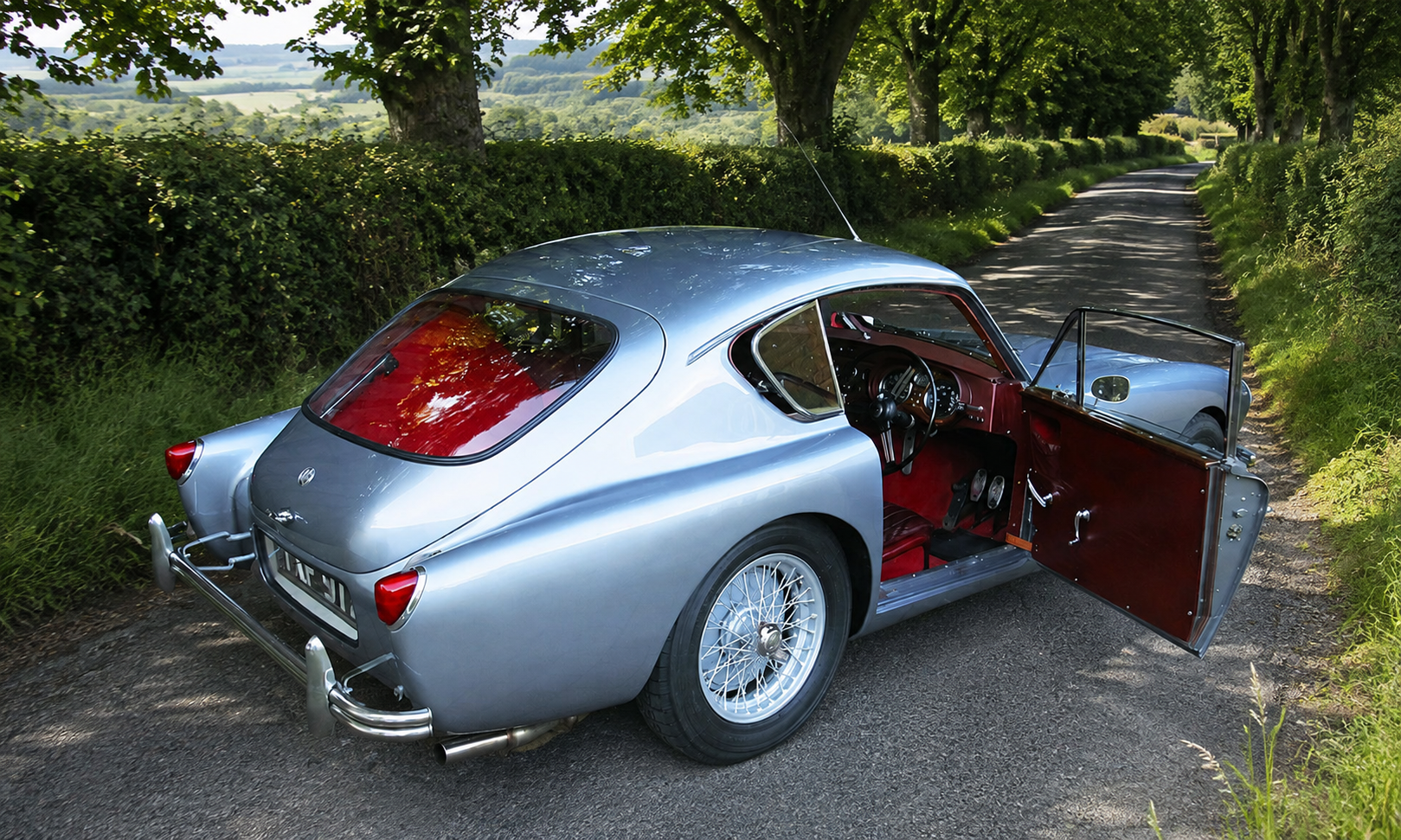 Silver AC Aceca coupé with red interior and door open, rear three-quarter view on a country lane