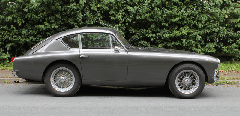 Grey AC Aceca-Bristol coupé, side profile, parked in front of a hedge