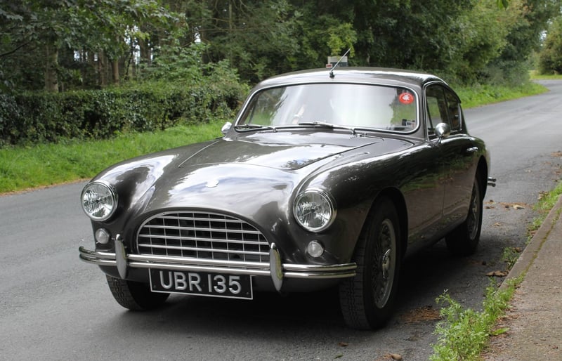 Dark grey AC Aceca-Bristol UBR 135 parked on a country road, seen from the front three-quarter angle with its grille and registration visible