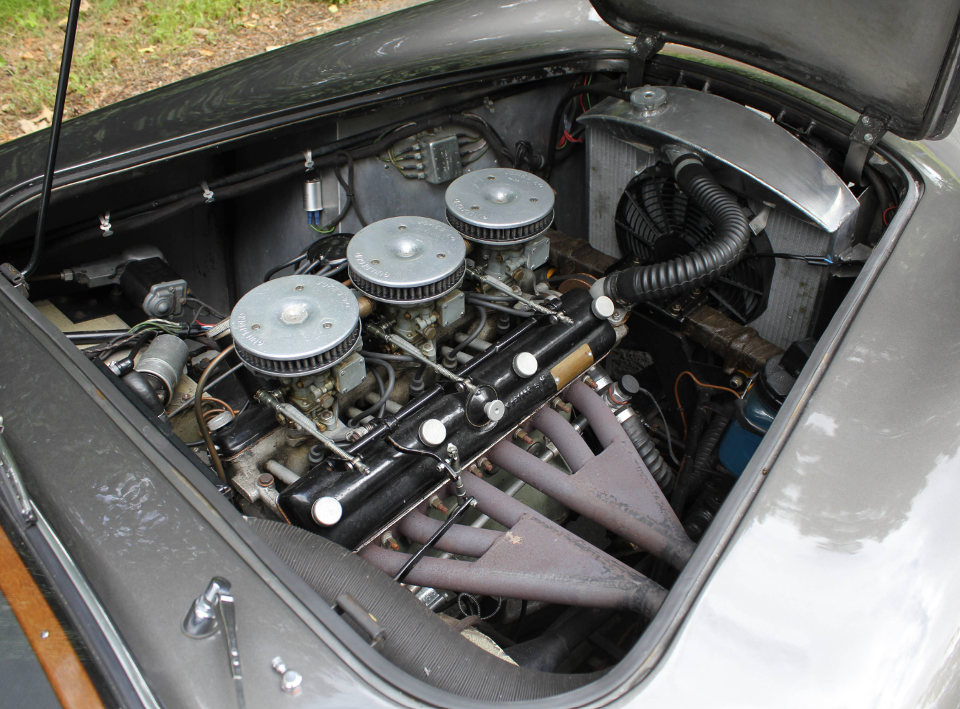 Bristol engine bay featuring triple Solex carburettors, a black valve cover and tubular exhaust manifold